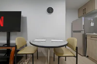 a kitchen with a table and chairs and a refrigerator at Modern Suite by Royal Alexandra Hospital l Free Parking WiFi Netflix in Edmonton