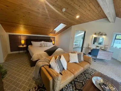 a large bedroom with a bed and a couch at Tyee Beach Oasis Bed and Breakfast in Nanoose Bay