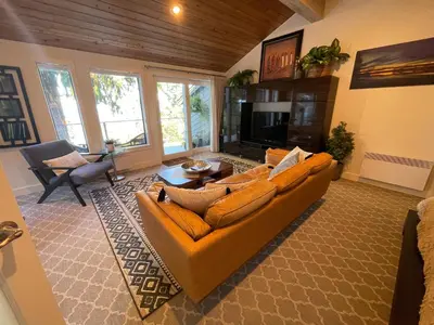 a living room with a couch and a television at Tyee Beach Oasis Bed and Breakfast in Nanoose Bay