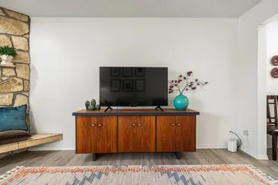 a living room with a tv on a wooden cabinet at Digital Nomad's Calgary Inner City Gem 3Bd, 5Bed, Sleeps 8, Main Level in Calgary