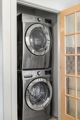three washing machines are stacked in a closet at Digital Nomad's Calgary Inner City Gem 3Bd, 5Bed, Sleeps 8, Main Level in Calgary