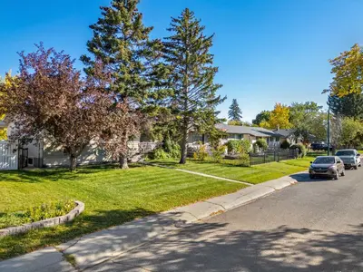 a house with a car parked on the side of a street at Digital Nomad's Calgary Inner City Gem 3Bd, 5Bed, Sleeps 8, Main Level in Calgary