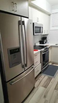 a kitchen with a stainless steel refrigerator and a microwave at Carsonway Basement Suite in Edmonton