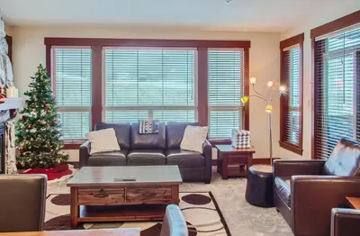 a living room with a couch and a christmas tree at Stonegate Resort Unit A205 in Big White