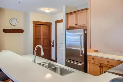 a kitchen with a sink and a refrigerator at Stonegate Resort Unit A205 in Big White