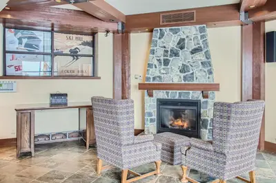 a living room with two chairs and a fireplace at Stonegate Resort Unit A205 in Big White