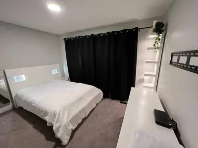 a bedroom with a bed and a black curtain at ZierHomes in Devon