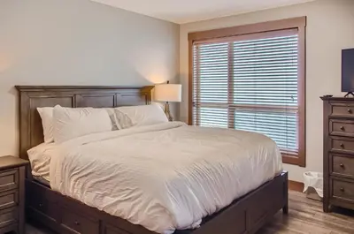 a bedroom with a large bed and a window at Stonegate Resort Unit B105 in Big White