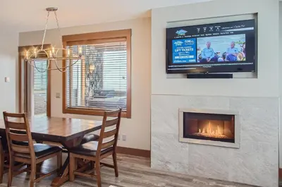 a dining room with a table and a fireplace at Stonegate Resort Unit B105 in Big White