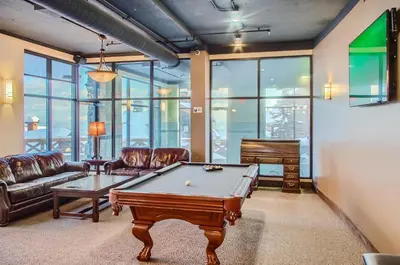 a living room with a pool table and a piano at Stonegate Resort Unit B302 in Big White