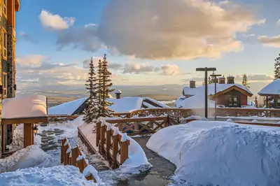 a snow covered yard with a house and a tree at Stonegate Resort Unit B303 in Big White