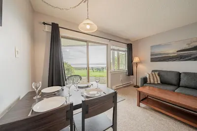 a living room with a table and a couch at Shorewater Resort, Qualicum Beach in Qualicum Beach