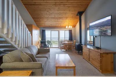 a living room with a couch and a tv at Shorewater Resort, Qualicum Beach in Qualicum Beach