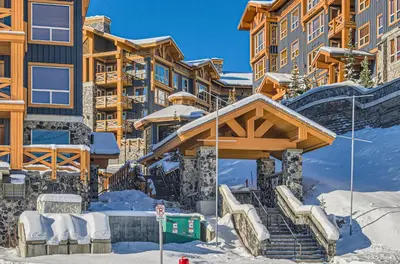 a ski lodge with a staircase in the snow at Stonegate Resort Unit B103 in Big White