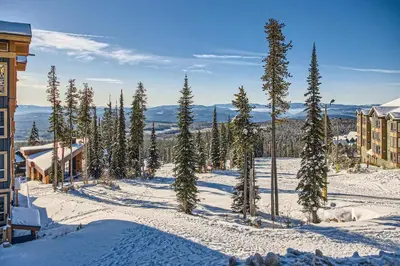 a group of trees in the snow next to a building at Stonegate Resort Unit C202 in Big White
