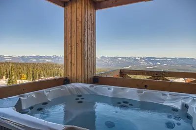 a hot tub with a view of a mountain at Stonegate Resort Unit C106 in Big White