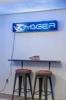 a table with two stools under a blue sign at Voyager's Hub- Calgary InnerCity 3BD 4Bed Sleeps 8 in Calgary