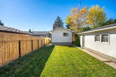 a backyard with a fence and a grass yard at Voyager's Hub- Calgary InnerCity 3BD 4Bed Sleeps 8 in Calgary