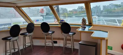 a bar on a boat with stools in front of a window at Shangri-la Cheer in Vancouver
