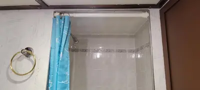 a shower with a blue shower curtain in a bathroom at Shangri-la Cheer in Vancouver