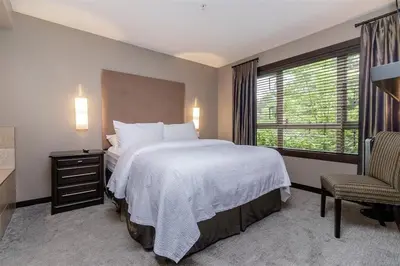 a bedroom with a large bed and a window at Stylish Family Condo at Beachfront Resort in Parksville