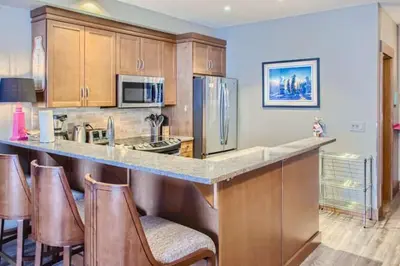 a kitchen with a counter and some brown cabinets at Stonegate Resort Unit B107 in Big White