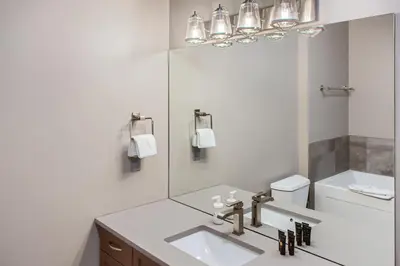 a white bathroom with a sink and a mirror at Stonegate Resort Unit B401 in Big White