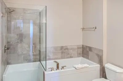 a bathroom with a shower and a tub and a toilet at Stonegate Resort Unit B401 in Big White