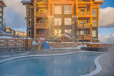 a swimming pool in front of a building in the snow at Stonegate Resort Unit A402 in Big White
