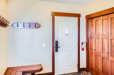 a hallway with a white door and a wooden cabinet at Stonegate Resort Unit C304 in Big White