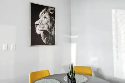 a dining room table with a lion picture on the wall at Elevated Elegance in Calgary