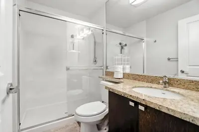 a bathroom with a shower and a toilet and a sink at Elevated Elegance in Calgary