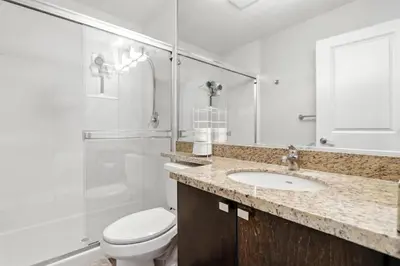 a bathroom with a toilet and a sink and a shower at Elevated Elegance in Calgary