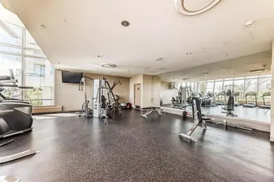 a gym with cardio equipment and a large mirror at Elevated Elegance in Calgary
