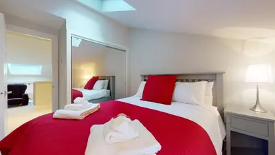 a bedroom with a red bed with towels on it at TELEMARK 25 Ski-In Ski-Out Access Steps To Ski Lifts Renovated Townhome in Whistler