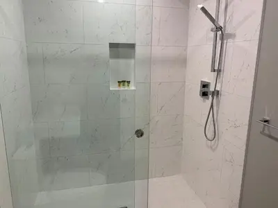 a bathroom with a shower with a glass door at TELEMARK 25 Ski-In Ski-Out Access Steps To Ski Lifts Renovated Townhome in Whistler