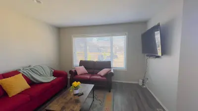 a living room with a red couch and a chair at Sylvan Lake Retreat I 122A Hinshaw Drive, Sylvan Lake in Sylvan Lake