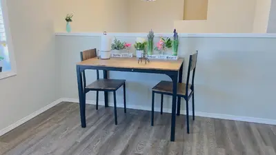 a table with two chairs and a table with flowers on it at Sylvan Lake Retreat I 122A Hinshaw Drive, Sylvan Lake in Sylvan Lake