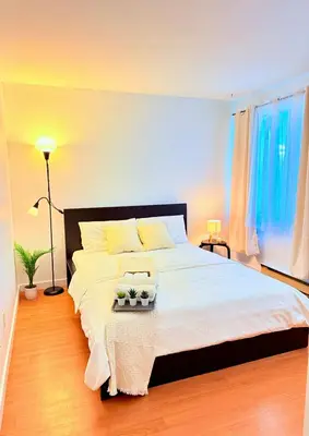 a bedroom with a large bed with white sheets at Private Room In The Heart Of The City in Vancouver