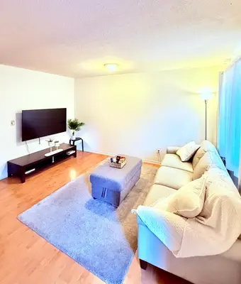 a living room with a couch and a tv at Private Room In The Heart Of The City in Vancouver