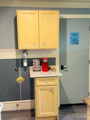 a kitchen with wooden cabinets and a red appliance on a counter at Unitrip King bed in Richmond