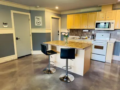 a kitchen with a large island with two bar stools at Unitrip King bed in Richmond