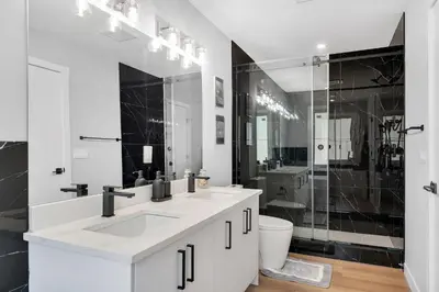 a white bathroom with two sinks and a shower at Your stay at Haysboro in Calgary