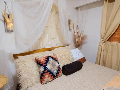a bed with two pillows on top of it at Cozy Boho Room at the Heart of Vancouver! Private Parking, Self Check-in & just 4 mins to Metrotown! in Burnaby