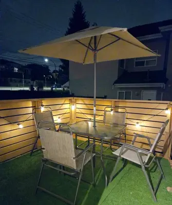 a table and chairs with an umbrella on a patio at Cozy Boho Room at the Heart of Vancouver! Private Parking, Self Check-in & just 4 mins to Metrotown! in Burnaby