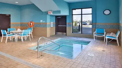 a pool in a waiting room with chairs and a table at Holiday Inn Hotel & Suites Edmonton Airport Conference Centre by IHG in Nisku
