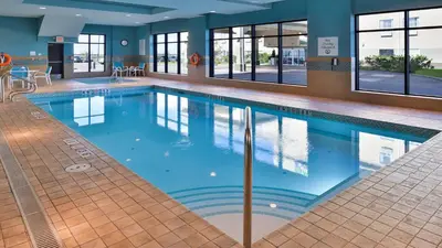 a large swimming pool with blue water in a building at Holiday Inn Hotel & Suites Edmonton Airport Conference Centre by IHG in Nisku