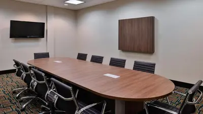 a conference room with a wooden table and chairs at Holiday Inn Hotel & Suites Edmonton Airport Conference Centre by IHG in Nisku