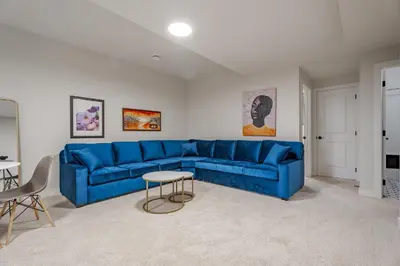 a living room with a blue couch and a table at Luxe Suite close to Spruce Meadows in Priddis