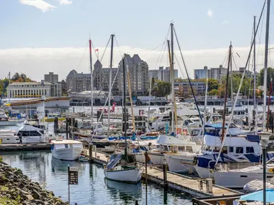 a group of boats docked in a harbor with a city at Coastal Charm - min 3-Day Stay Breathtaking Views with Work Desk by Victoria Prime! in Victoria